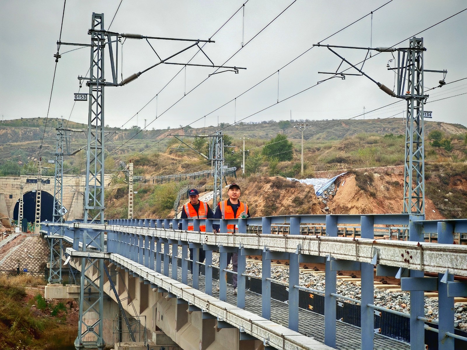 圖為應急小組人員徒步通過隧道后在鐵路橋上排查應急線路
